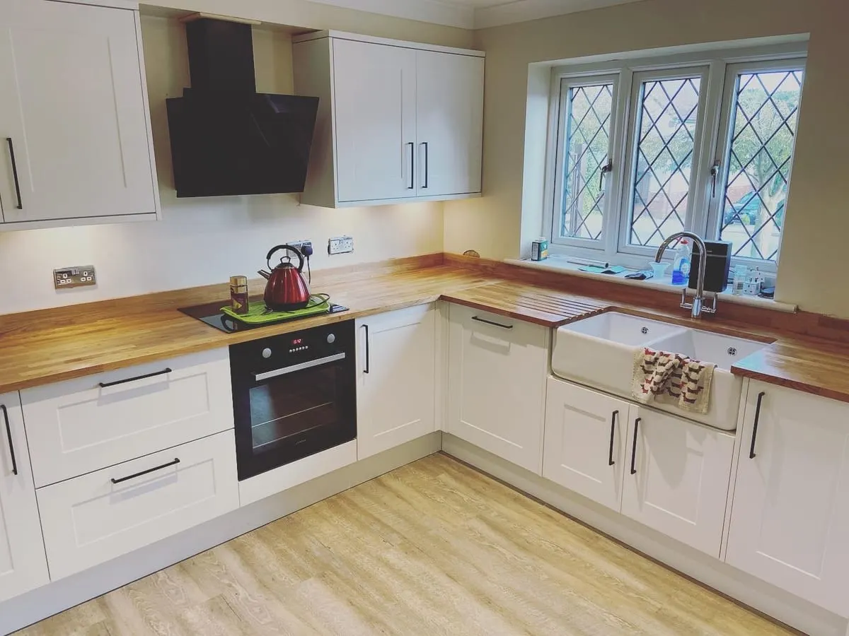 Cream Shaker Kitchen with Oak Worktops Cream shaker kitchen with solid oak worktops, ceramic butler sink under a leaded window and black extractor