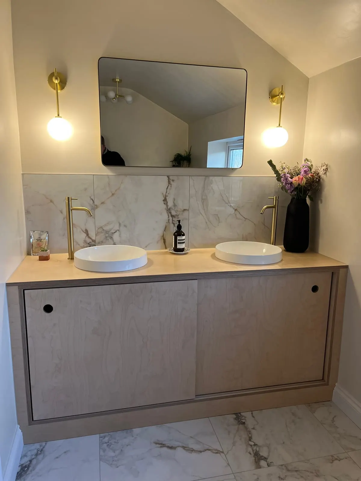 Birch Ply Double Vanity Unit Floating birch ply double vanity unit with twin round basins, brass taps and marble splashback