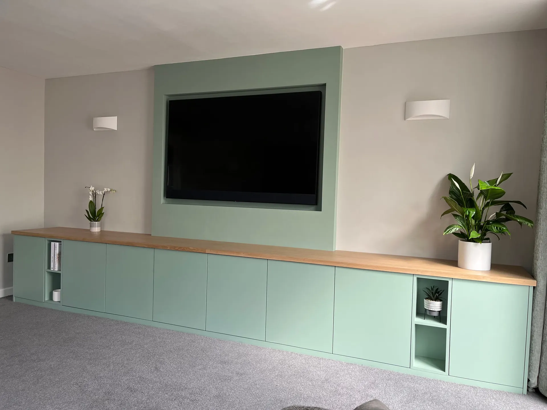 Sage Green Media Wall Unit Full-width fitted sage green media unit with solid oak top and recessed TV panel above