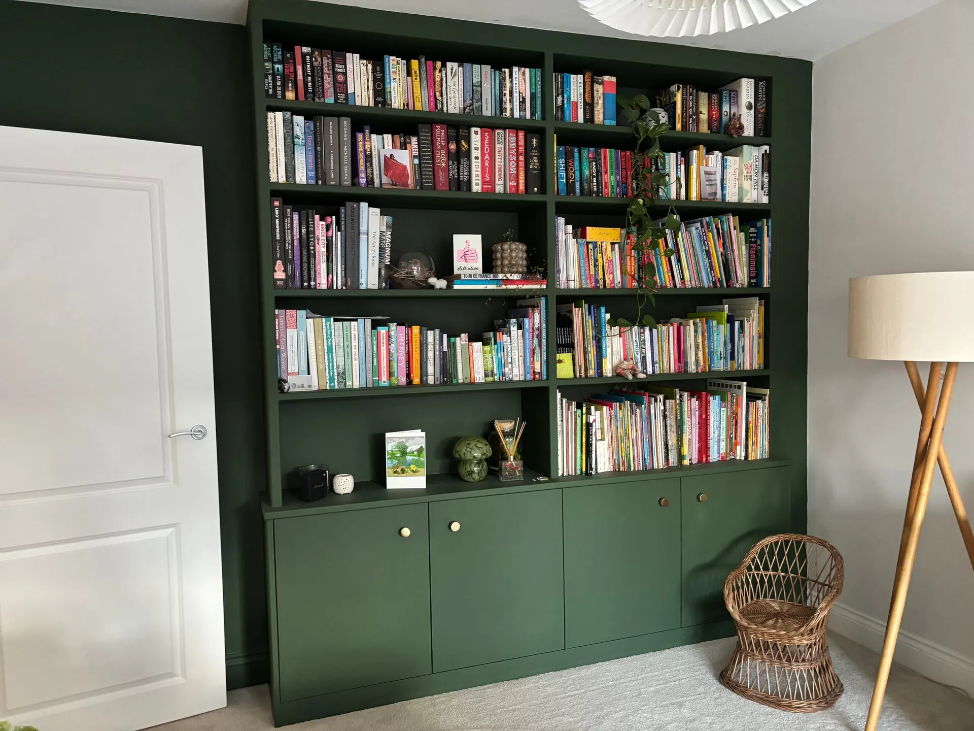 Dark Green Fitted Bookcase Floor-to-ceiling fitted bookcase painted deep green with brass-knobbed cupboards and shelves full of books