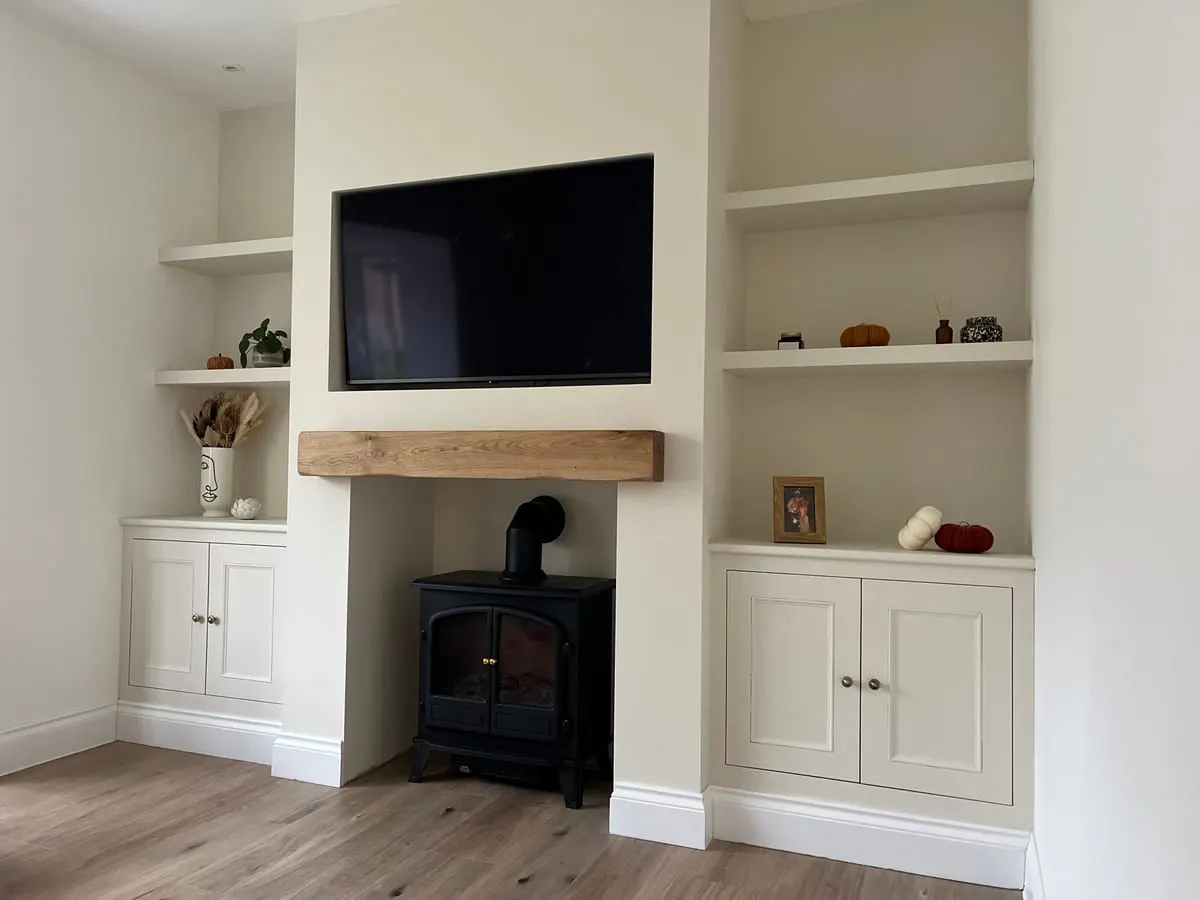 Alcove Cupboards and Floating Shelves Cream fitted alcove cupboards and floating shelves either side of a log burner with oak beam mantel